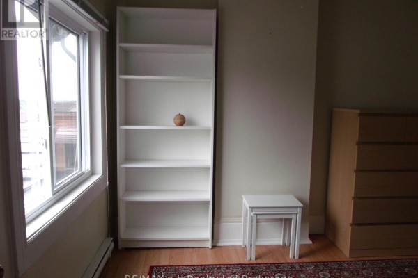 A tall white bookshelf next to a window, with a dresser on the right. - 1 - 350 Dundas Street, Woodstock