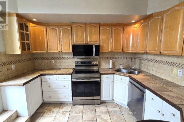 Kitchen featuring U-shaped counter, stainless steel appliances, and tiled backsplash. - 1 - 41 Dunlop Street E, Barrie