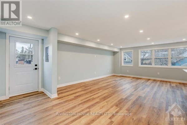 Spacious, light-filled living area with light blue walls, white trim, and light wood laminate flooring. - 1 - 413 Donald B Munro Drive, Ottawa