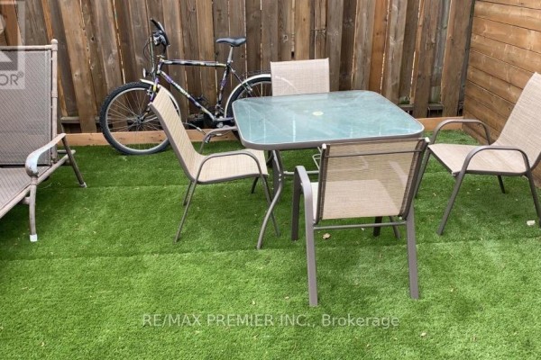 Outdoor patio with a glass-top table, four chairs, a lounge chair, and a bicycle. - 1 - 50 Pape Avenue, Toronto
