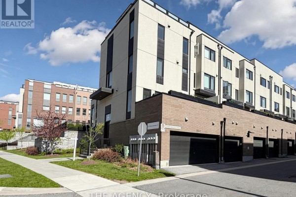 Row of townhouses with modern architecture, beige siding, brick lower levels, and garages. - 1 - 55 Thomas Mulholland Drive, Toronto