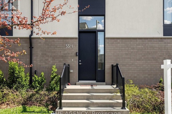 Front entrance of a townhouse with a dark door, concrete steps, and black railings. - 1 - 55 Thomas Mulholland Drive, Toronto