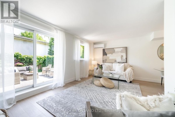 Living room with sliding glass doors leading to a private patio with seating. - 1 - 684 Dynes Road, Burlington