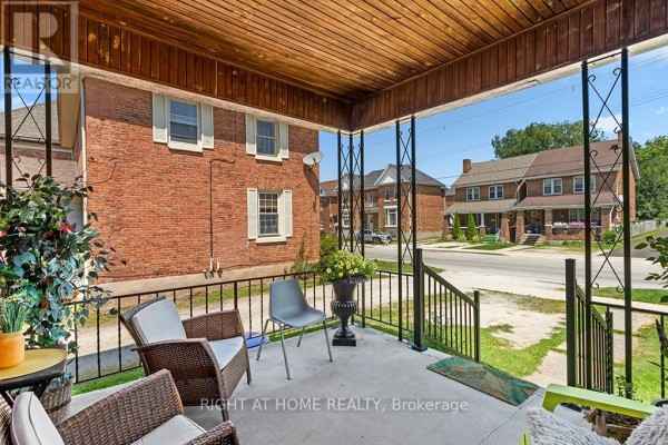 Another view of the covered porch with seating and a street view. - 1 - 774 4th Avenue E, Owen Sound