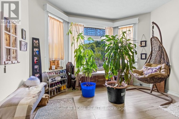 Living room with bay window, plants, and a hanging chair. - 1 - 774 4th Avenue E, Owen Sound