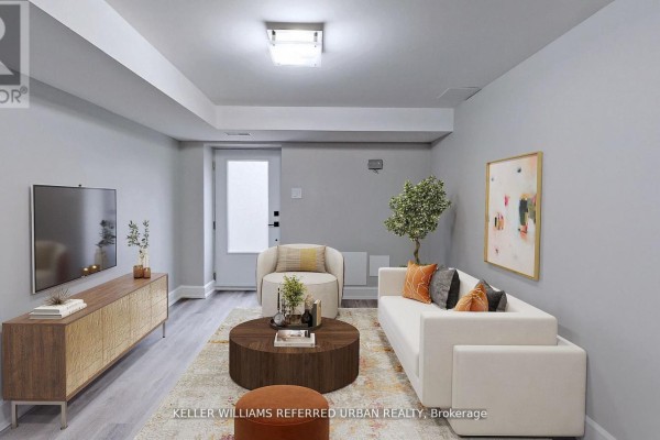 Modern living room with gray walls, white furniture, and a round coffee table, featuring natural light. - 1 - 783 Dufferin Street, Toronto