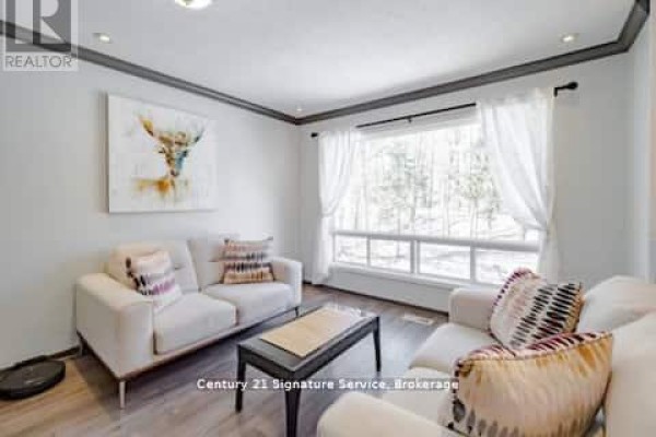 Living room with two white sofas, a coffee table, and a large window with white curtains. - 1 - 879 Stephenson Road E, Huntsville