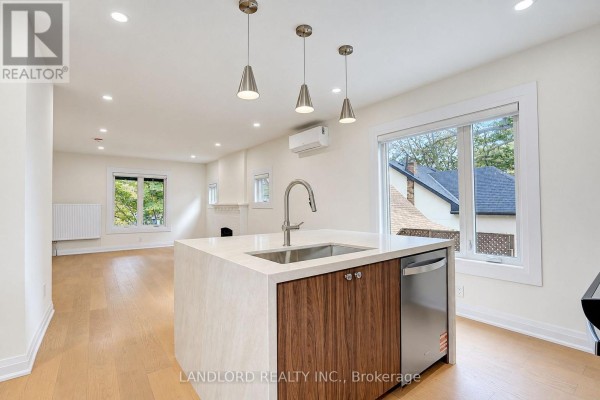 Open-concept living area and kitchen with a central island and large windows. - 1 - 92 Neville Park Boulevard, Toronto