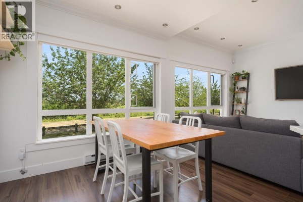 Open concept living and dining area with large windows showing a tree-lined view. - 1 13028 No. 2 Road, Richmond