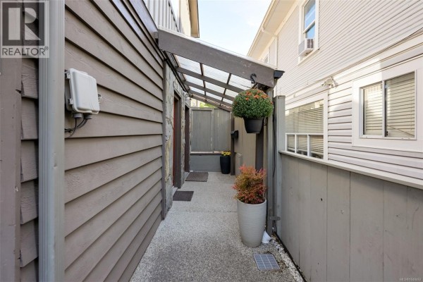 Interior entryway with a red front door, yellow wall, and tiled staircase. - 1 132 Michigan St, Victoria