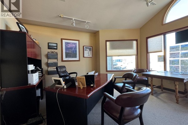 Office interior showing a large desk with chairs, a credenza, and multiple windows with blinds. - 1 181 Broadway Street E, Fort Qu Appelle
