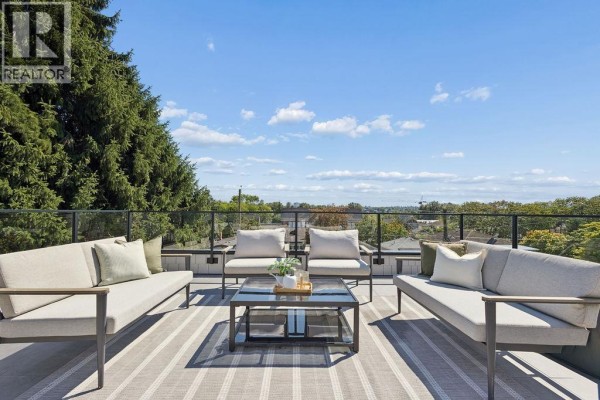 Rooftop patio with light grey sectional sofas, chairs, coffee table, and striped rug. - 1 2124 E 8 Avenue, Vancouver