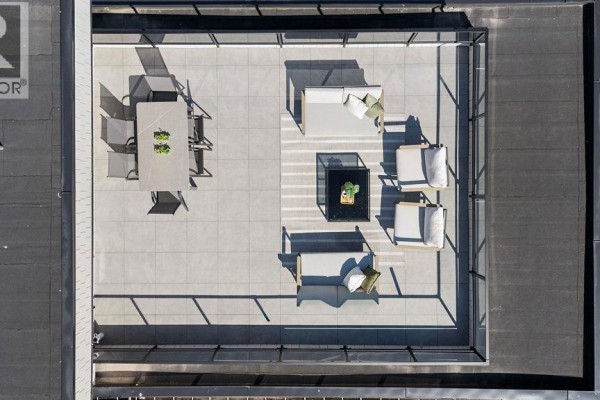 Aerial view of rooftop patio with dining set, lounge furniture, and glass railings. - 1 2124 E 8 Avenue, Vancouver