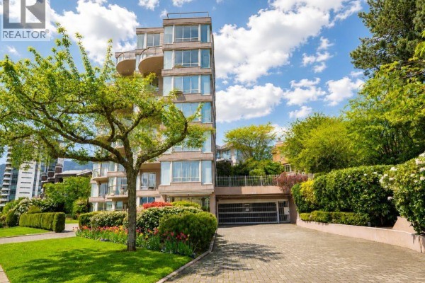 View of the apartment building's entrance, garage, and surrounding landscaped gardens. - 1 2243 Bellevue Avenue, West Vancouver