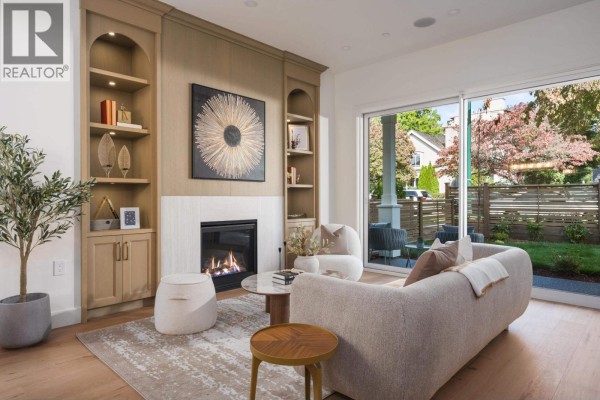 Living room with fireplace, sofa, view of backyard and street through sliding glass door. - 1 2344 W 45th Avenue, Vancouver