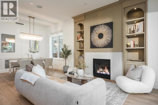 Living room and dining area with fireplace, modern furniture, and chandelier. - 1 2344 W 45th Avenue, Vancouver