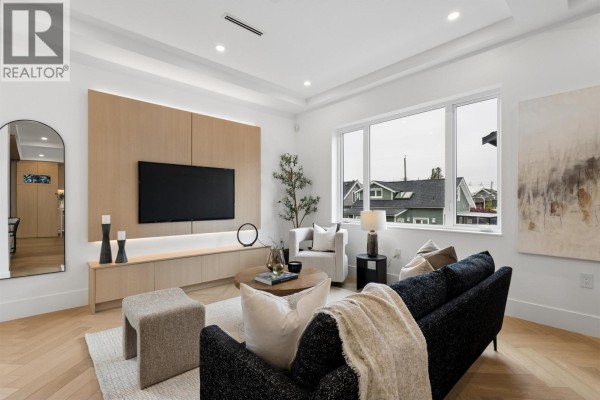 A bedroom with a white bed, large grey closet doors, and a window. - 1 3637 E 46th Avenue, Vancouver