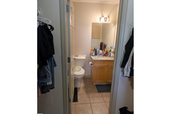View into a bathroom with tiled floor, vanity, and toilet. - 1-504, 4245 139 Av Nw Nw, Edmonton