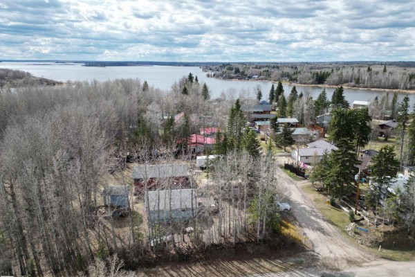 Aerial view of homes nestled amongst trees with a lake in the background. - #1 54114 Rge Road 52, Rural Lac Ste  Anne County