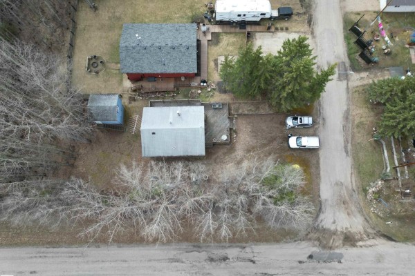 Top-down aerial view of houses, decks, a shed, and vehicles on a dirt road. - #1 54114 Rge Road 52, Rural Lac Ste  Anne County