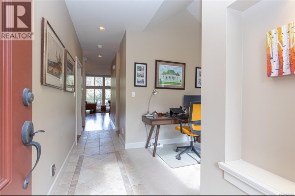 Interior hallway with tiled floor, desk area, and view through to a living space. - 1 551 Bezanton Way, Colwood