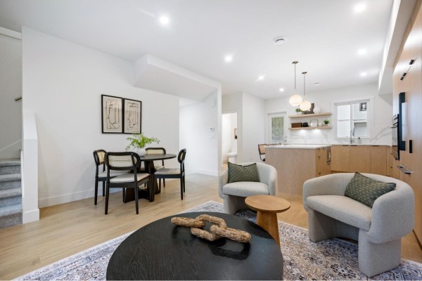 Dining area adjacent to the kitchen, featuring a round table and chairs with wicker seats. - 1 5993 143 Street, Surrey