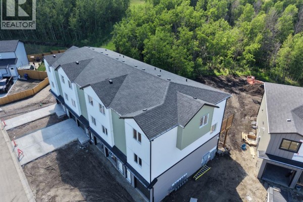 Aerial view of a newly constructed multi-unit building with light green and white siding. - 1-6, 10 Valarosa Park, Didsbury