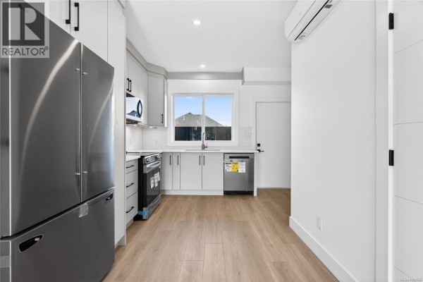 Spacious bathroom with a long vanity, white countertop, and a separate shower with glass doors. - 1 704 Beaver Creek Blvd, Campbell River