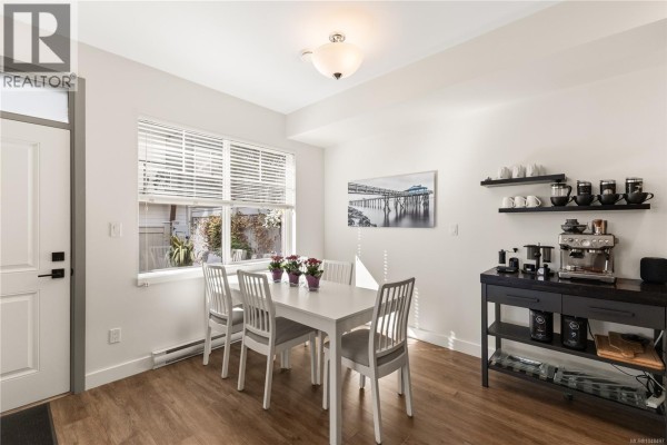 Dining area with white table and chairs, window with blinds, and modern coffee station. - 1 796 Island Hwy S, Campbell River
