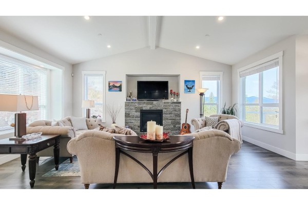 A room with a large safe, storage shelves, an easel with a painting, and a guitar. - 1 8295 Nixon Road, Eastern Hillsides, Chilliwack