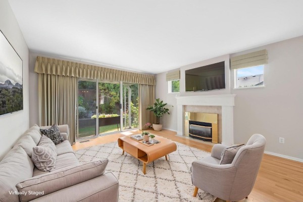 Living room with a fireplace, sofa, armchair, coffee table, and sliding glass doors. - 1 8889 212 Street, Langley