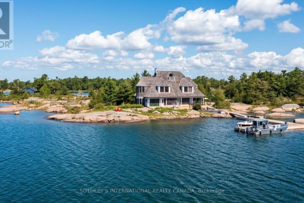 Island home with a boat docked beside it, surrounded by water. - 1 A307 Island, The Archipelago