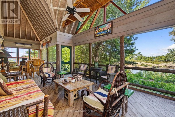 Screened porch with wicker furniture, wood ceiling, and water view - 1 A307 Island The Archipelago