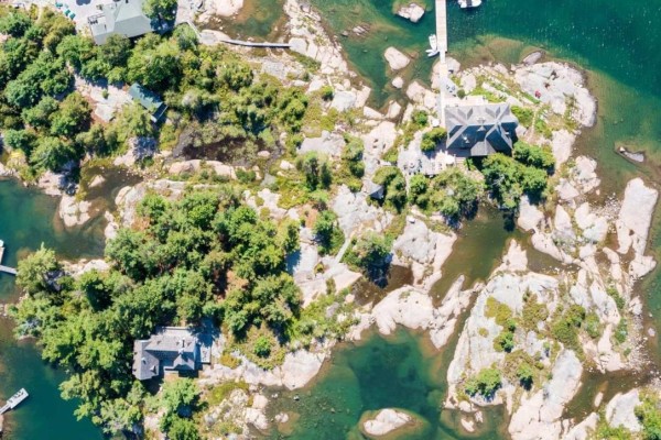 Aerial view of a large island with multiple houses and docks. - 1 A307 Island, The Archipelago
