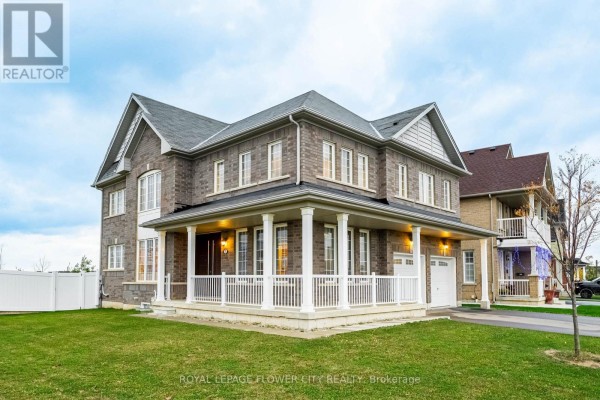 Side view of the house featuring a porch, lawn, and attached garage. - 1 Anderson Road, Brantford