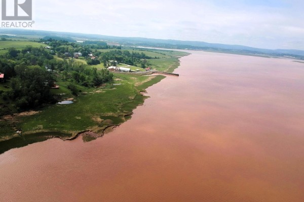 Aerial view of a coastline with a small harbor, grassy fields, and the wide, reddish body of water. - 1 Avon Spirit Lane, Avondale