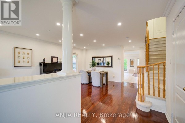 Interior view of a living area with hardwood floors, white trim, and a staircase. - 1 Aylesbury Gate, Markham
