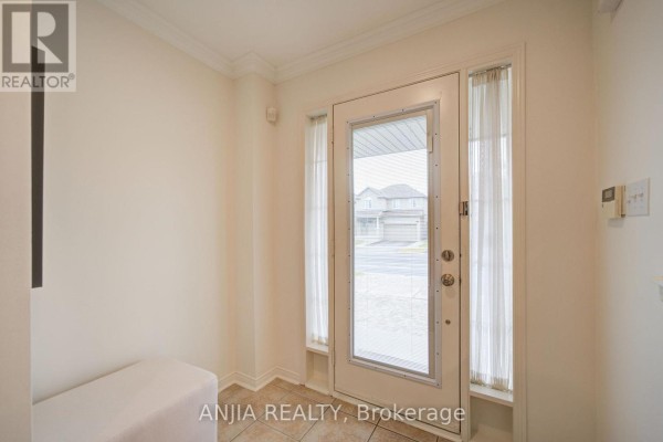 View through the interior front door shows a tiled entryway and windows looking outside. - 1 Aylesbury Gate, Markham