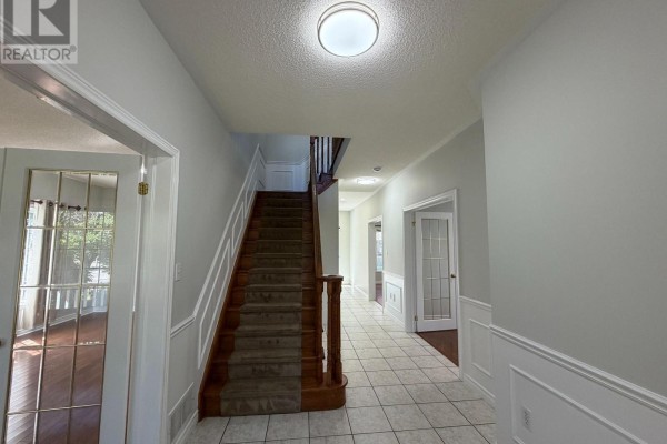 Covered front porch with a wooden front door, brick pillars, and white railing. - 1 Buman Court, Barrie