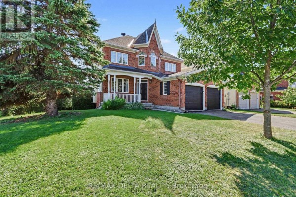 Front view of a red brick house with a covered porch and green lawn. - 1 Cheltonia Way, Ottawa