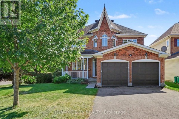 Exterior of a red brick house with a white porch and dark double garage doors. - 1 Cheltonia Way, Ottawa
