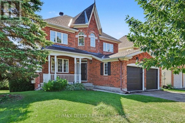 Red brick house with a large front lawn, mature trees, and a peaked roof. - 1 Cheltonia Way, Ottawa