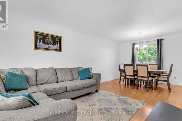 Living room with grey sectional sofa and dining area with a table and chairs. - 1 Cheswick Circle, London South