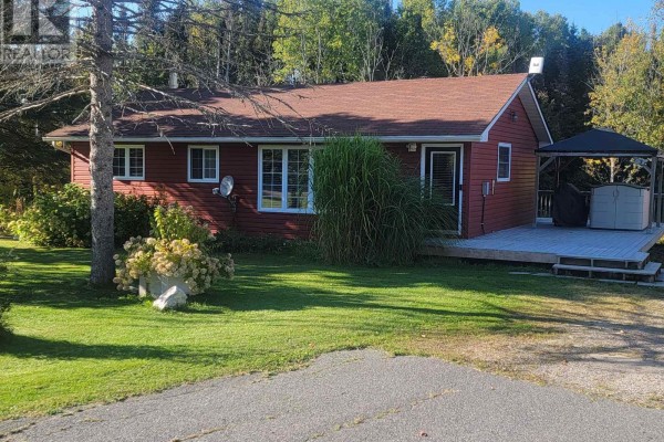 Front exterior of a red sided house with an orange roof, grassy lawn, and mature trees in summer. - 1 Christopher Lane, Armour