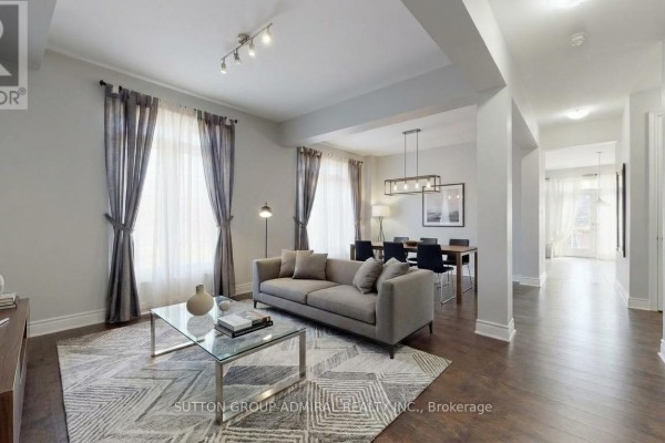 Living room with fireplace, sofa, and coffee table, open to dining area and kitchen. - 1 Citrine Drive, Bradford West Gwillimbury