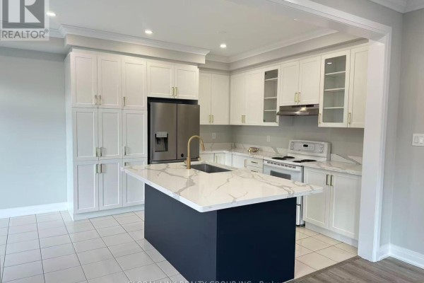 Kitchen featuring white cabinetry, a large island with a marble waterfall countertop, and stainless steel appliances. - 1 Copperhill Heights N, Barrie