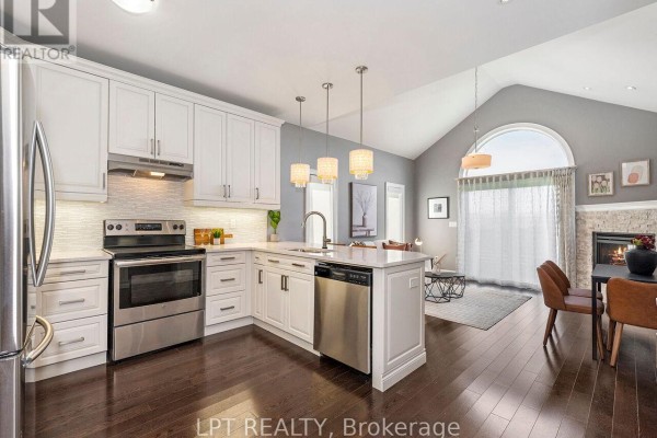 Open concept kitchen and living area with vaulted ceiling and gas fireplace. - 1 Dorchester Boulevard S, St  Catharines