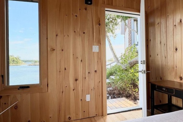 Bedroom with wood paneling, water view window, and exterior door - 1 Island 352c Carling