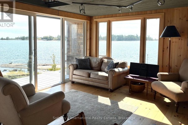 Living room with sofa, armchair, and large windows overlooking water - 1 Island 352c Carling
