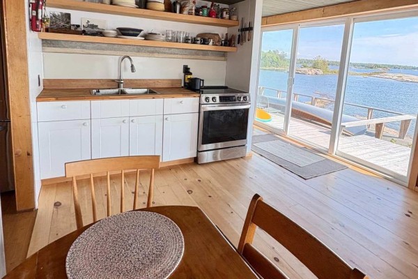 Kitchen with white cabinets, wooden countertops, stainless steel oven, and waterfront view - 1 Island 352c Carling